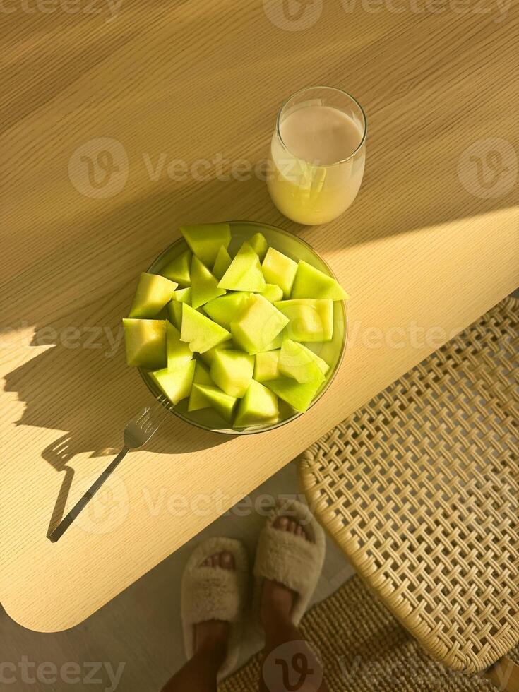 Enjoying fresh melon slices and juice in a cozy setting during the morning photo