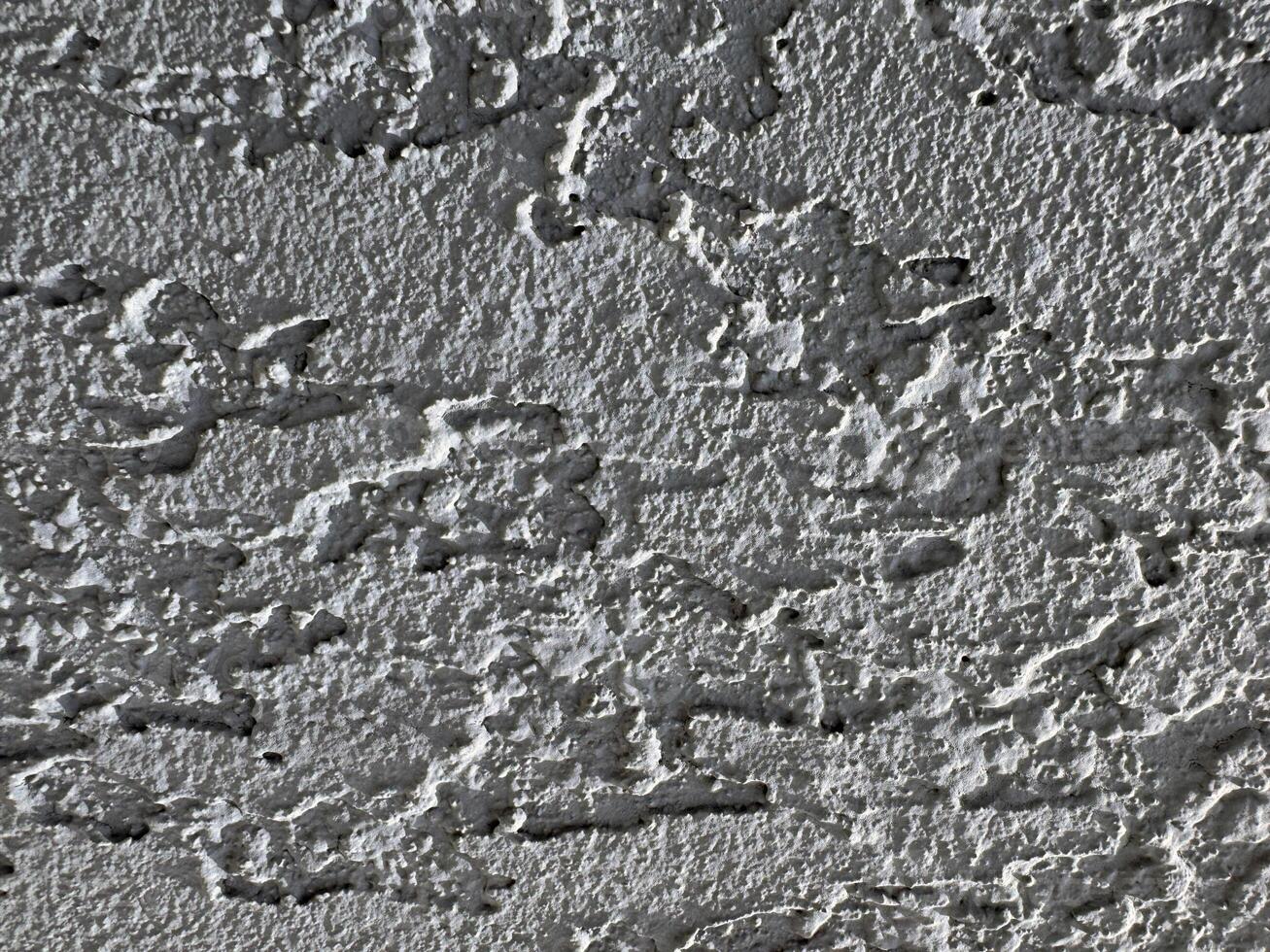 Textured wall surface with intricate patterns and shadows in natural light photo