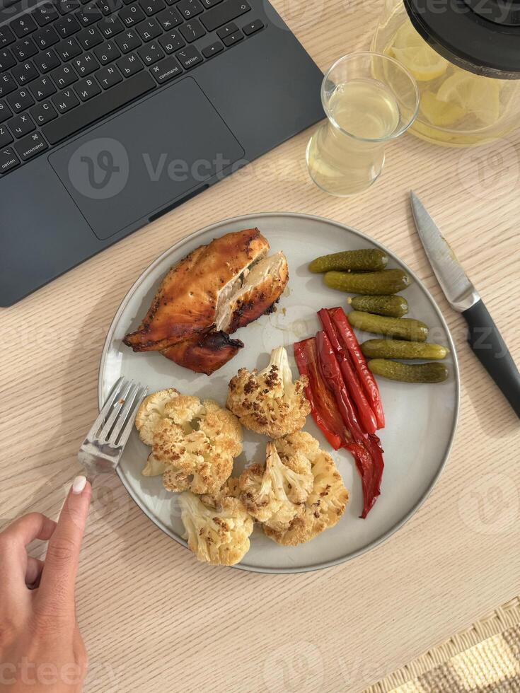 Delicious meal featuring roasted chicken, vegetables, and pickles served on a plate photo