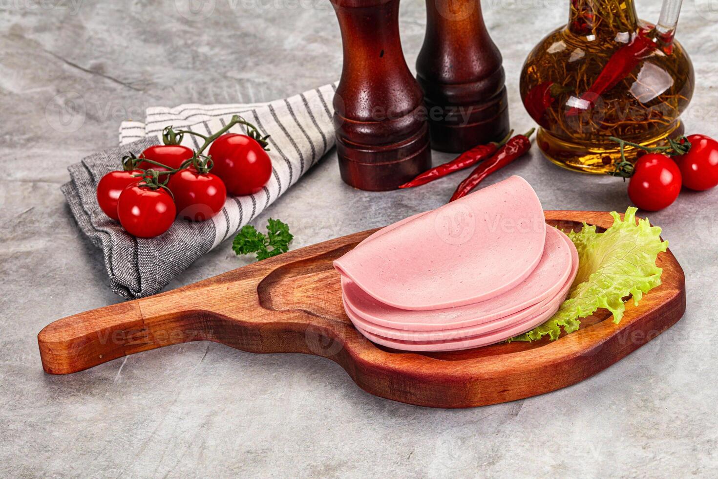 Sliced boiled sausage over board photo