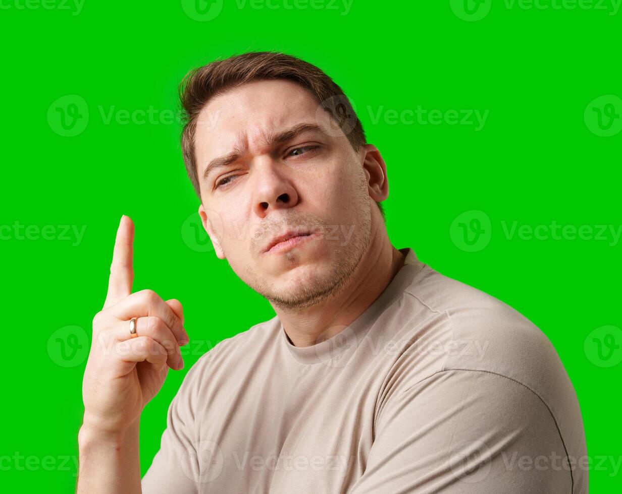 Thoughtful man gestures against a green background photo