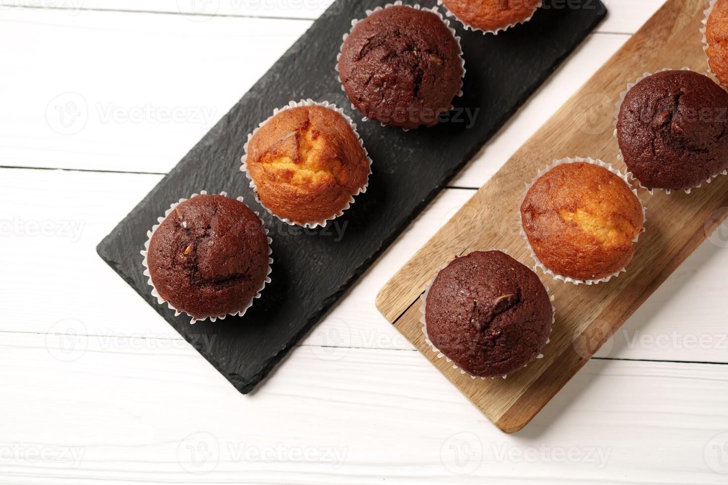 Delightful chocolate and vanilla muffins arranged on wooden serving boards in a bright kitchen setting photo