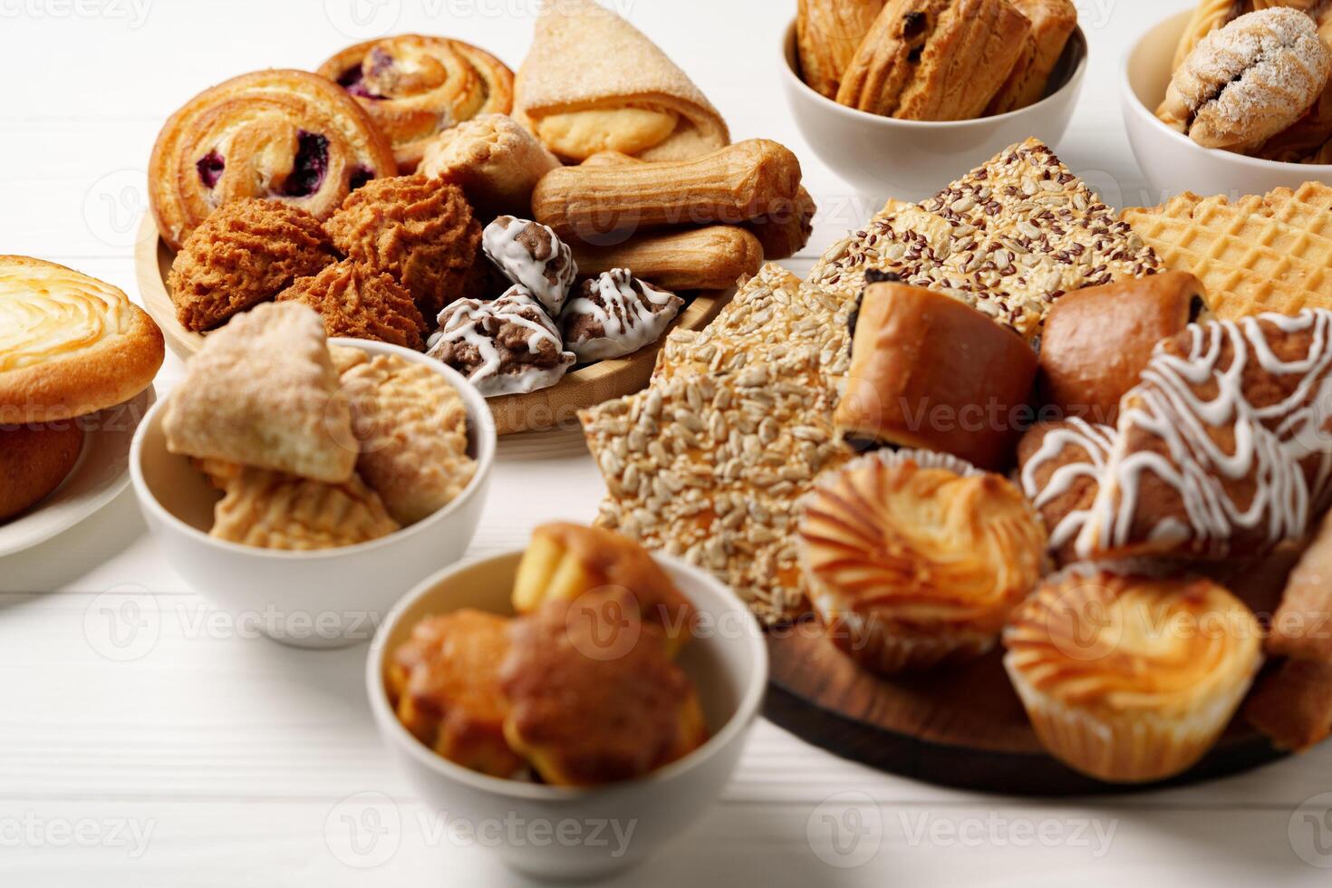 Assortment of baked treats displayed on wooden boards and white bowls for a delightful dessert experience photo