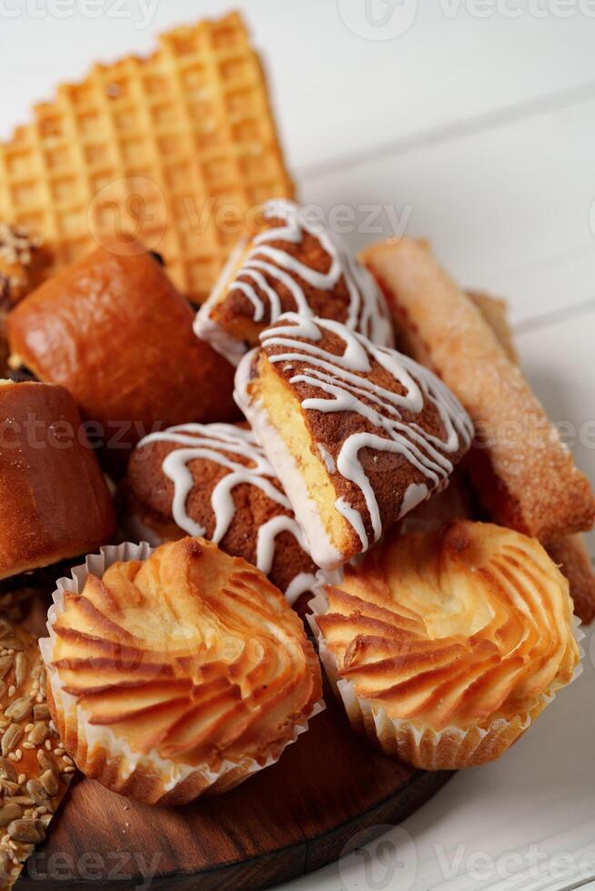 Assorted pastries and sweets arranged on a wooden platter during a food gathering photo
