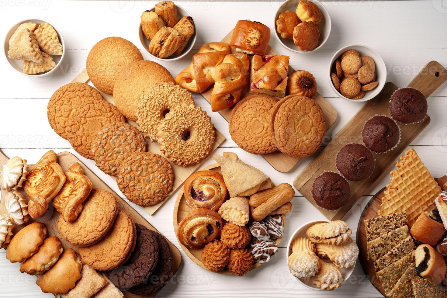 Delicious assortment of freshly baked cookies and pastries displayed on a wooden table photo