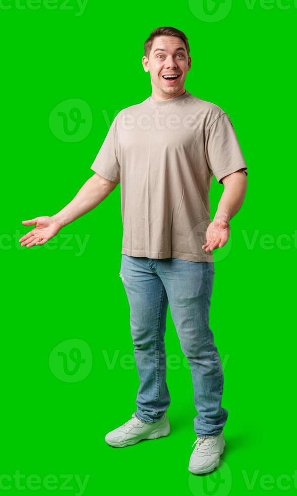 Young man in casual clothing stands with open arms against a vibrant green background photo
