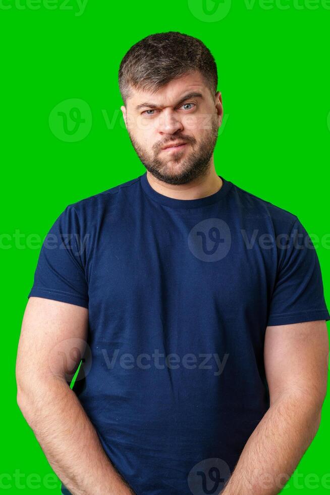 Man expressing confusion with crossed arms in front of a bright green background photo