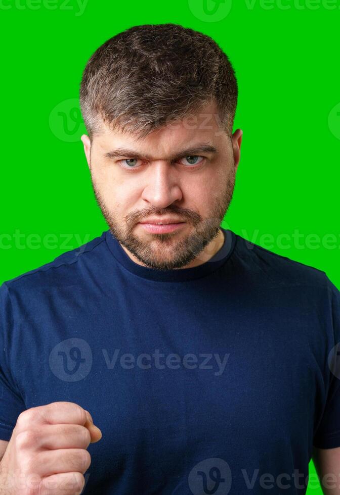 Assertive man making a fist against a bright green backdrop photo
