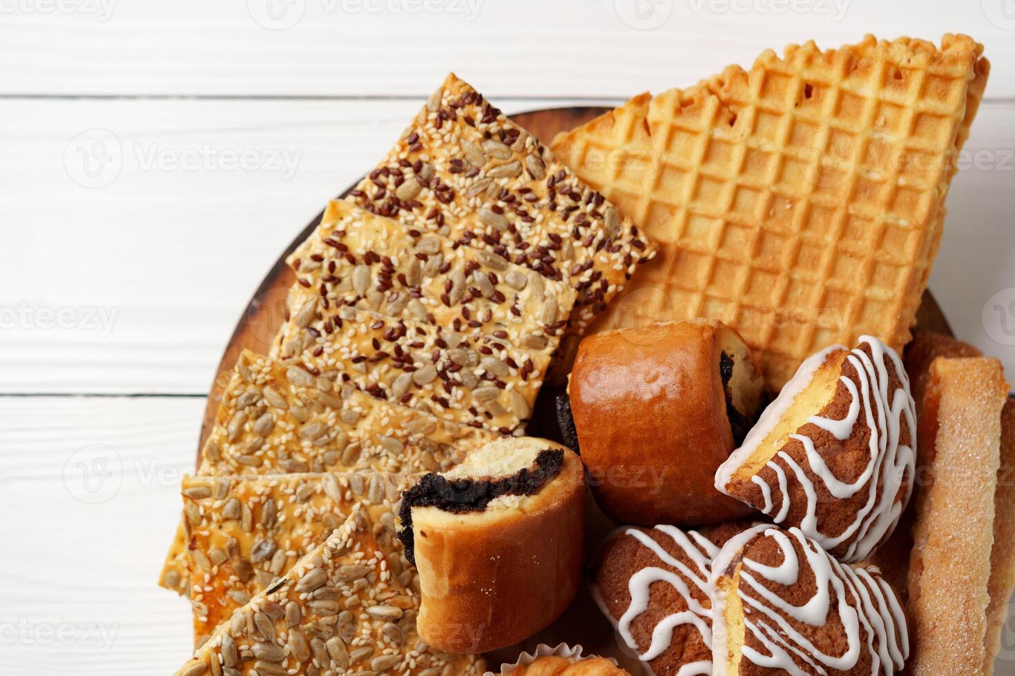 Assortment of traditional desserts displayed on a wooden plate with a rustic background photo