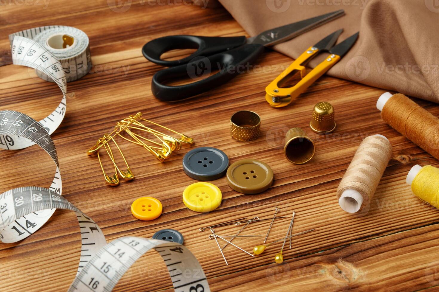 Crafting tools and materials arranged on a wooden table for sewing projects photo