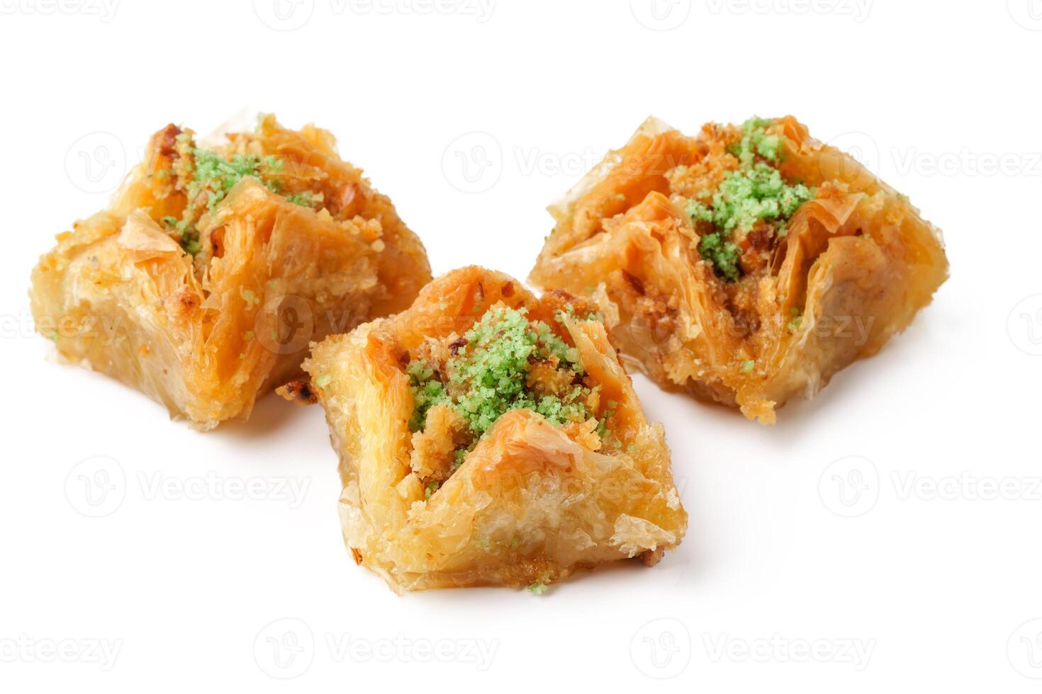 Deliciously prepared baklava with vibrant green garnish presented on a clean white surface photo