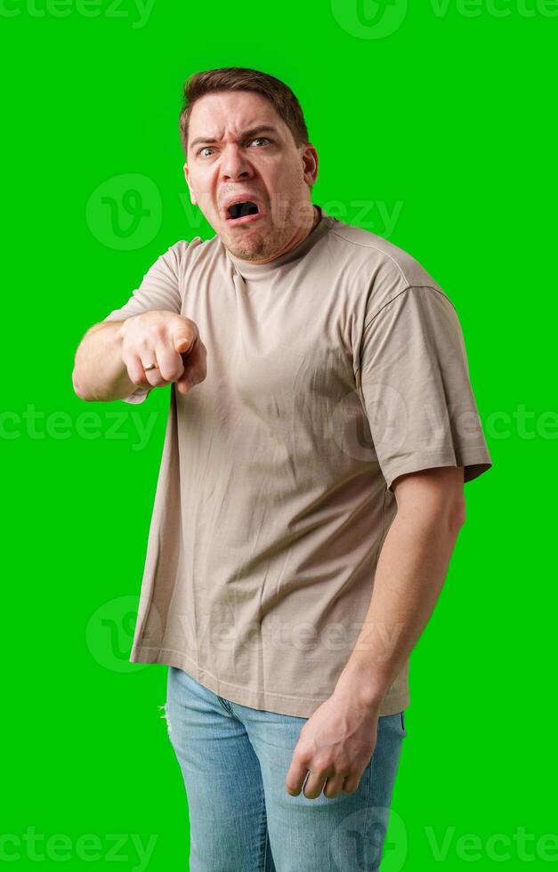 Man expressing anger and pointing in a plain t-shirt with a bright green background photo