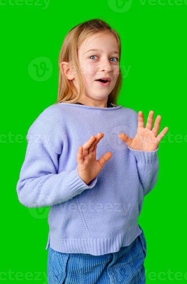 A young girl expresses surprise while smiling, with bright green background photo