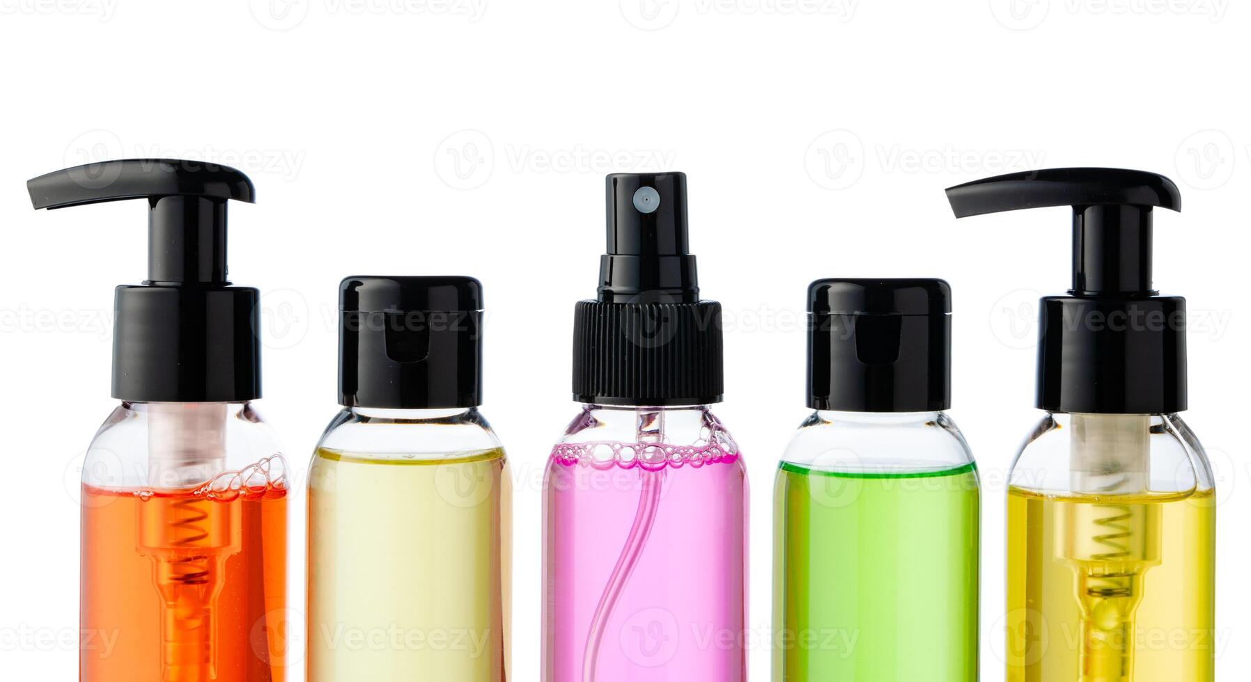 Various bottles with colored liquids and pumps arranged on white background photo
