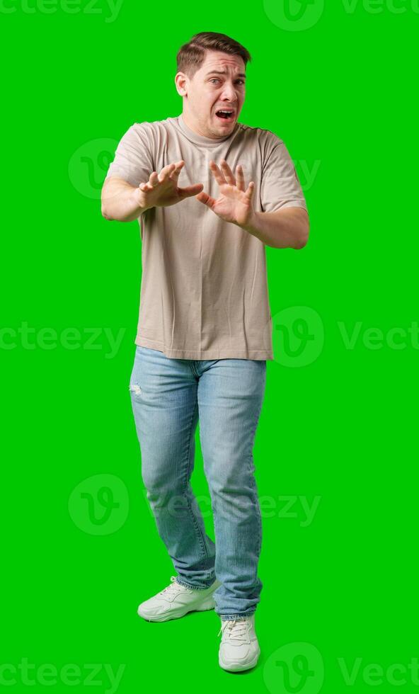 Man expressing fear while standing against a bright green background photo