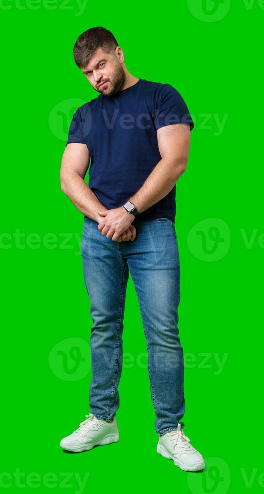 Man standing with a thoughtful expression in a casual outfit against a green background photo