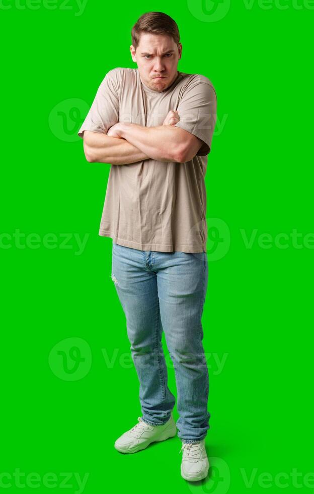 Man with a neutral expression poses against a bright green backdrop photo