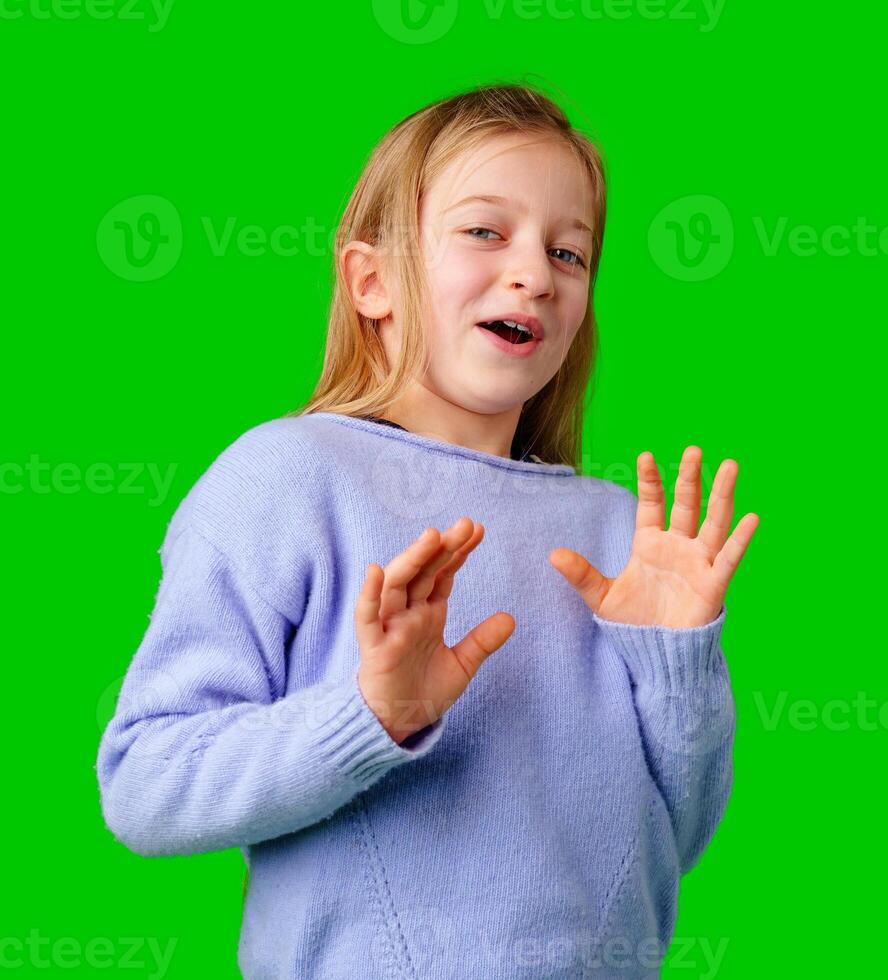 A young girl expresses surprise while smiling, with bright green background photo
