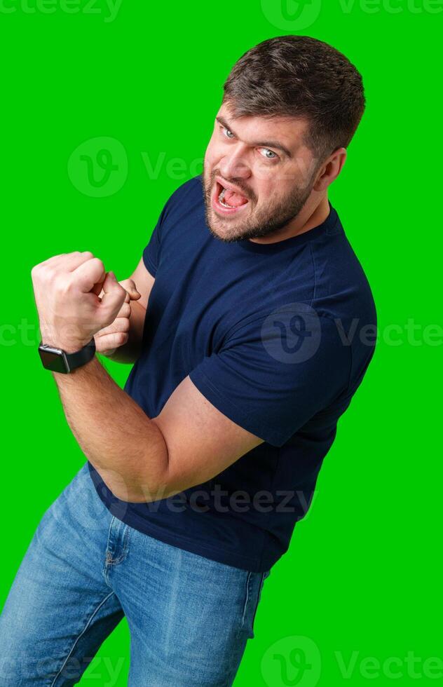 A strong man with fists raised, smiling confidently, on a bright green background photo