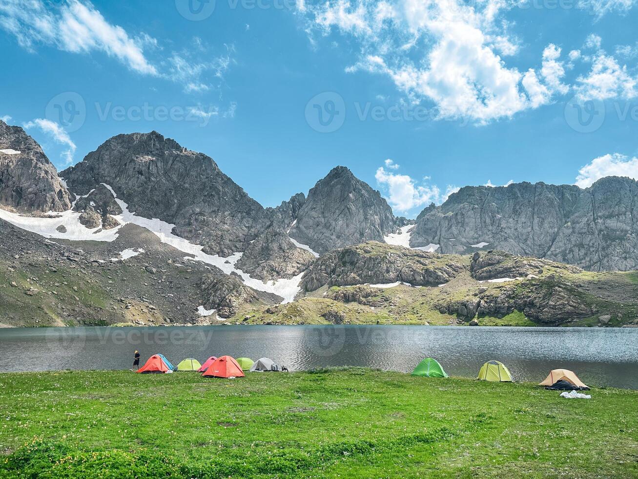 Camping tent by the lake in front of the mountain. photo