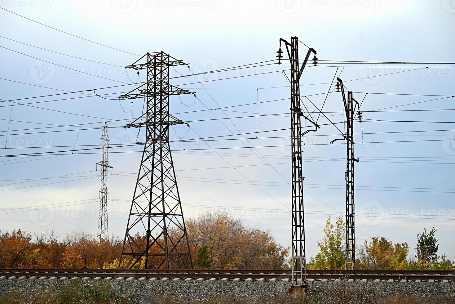 High-voltage power lines passing through a plowed field, on the background of a beautiful cloudy sky. photo
