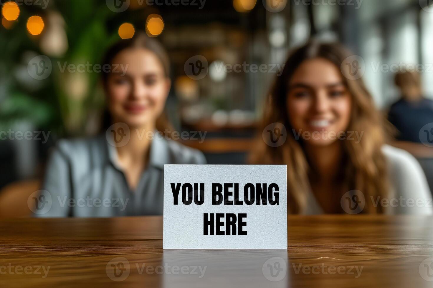 You belong here message written on white card on table photo
