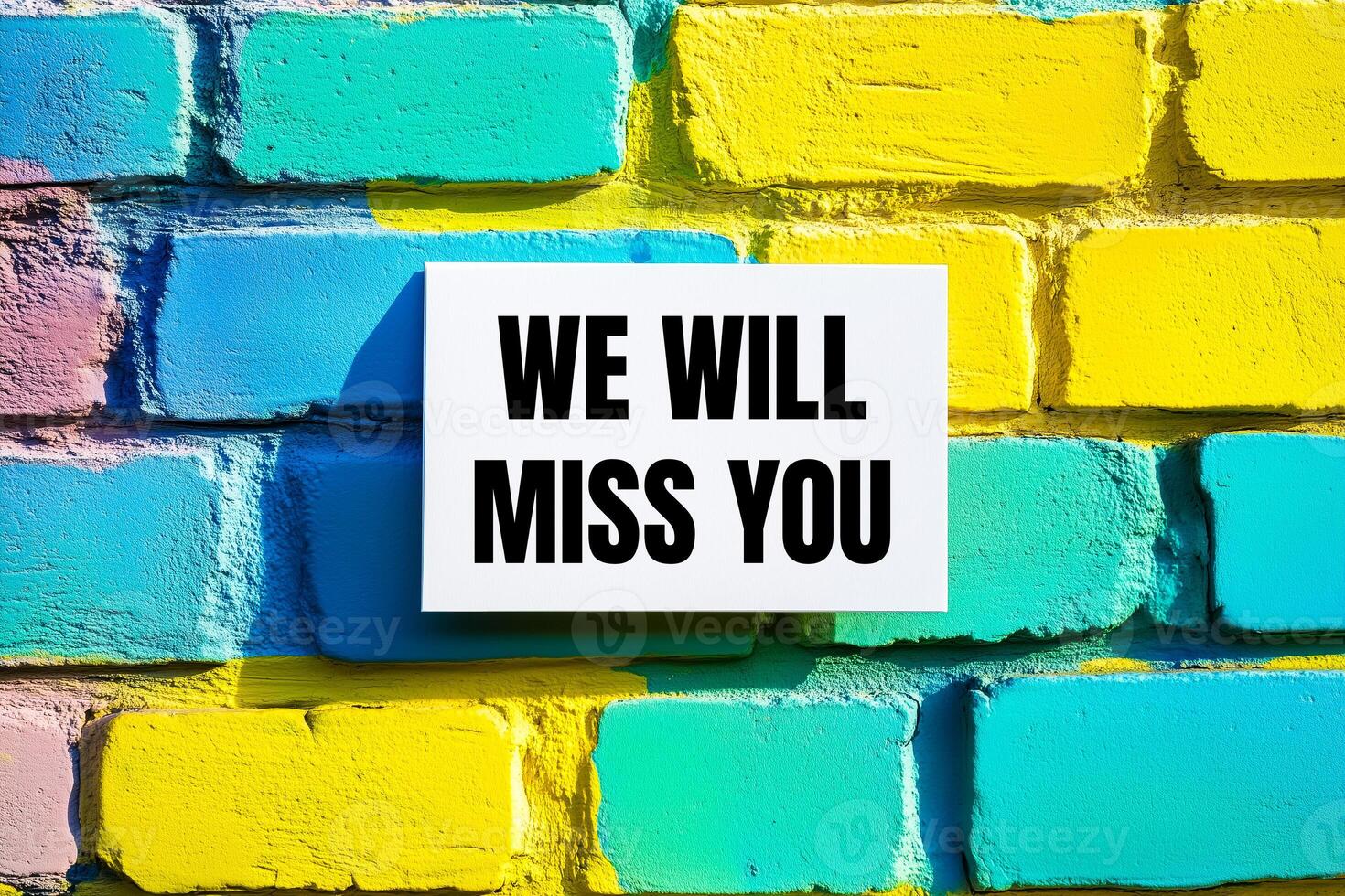 We will miss you message written on white card on colorful wall. Conceptual we will miss you symbol. Copy space. photo
