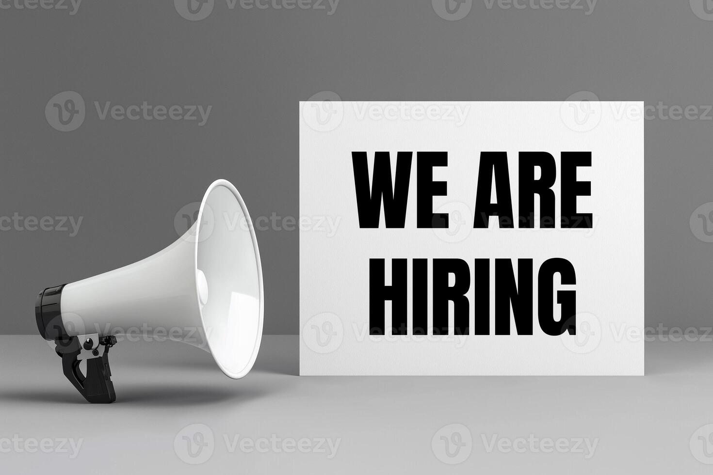 We are hiring message written on white card with a megaphone on gray background photo