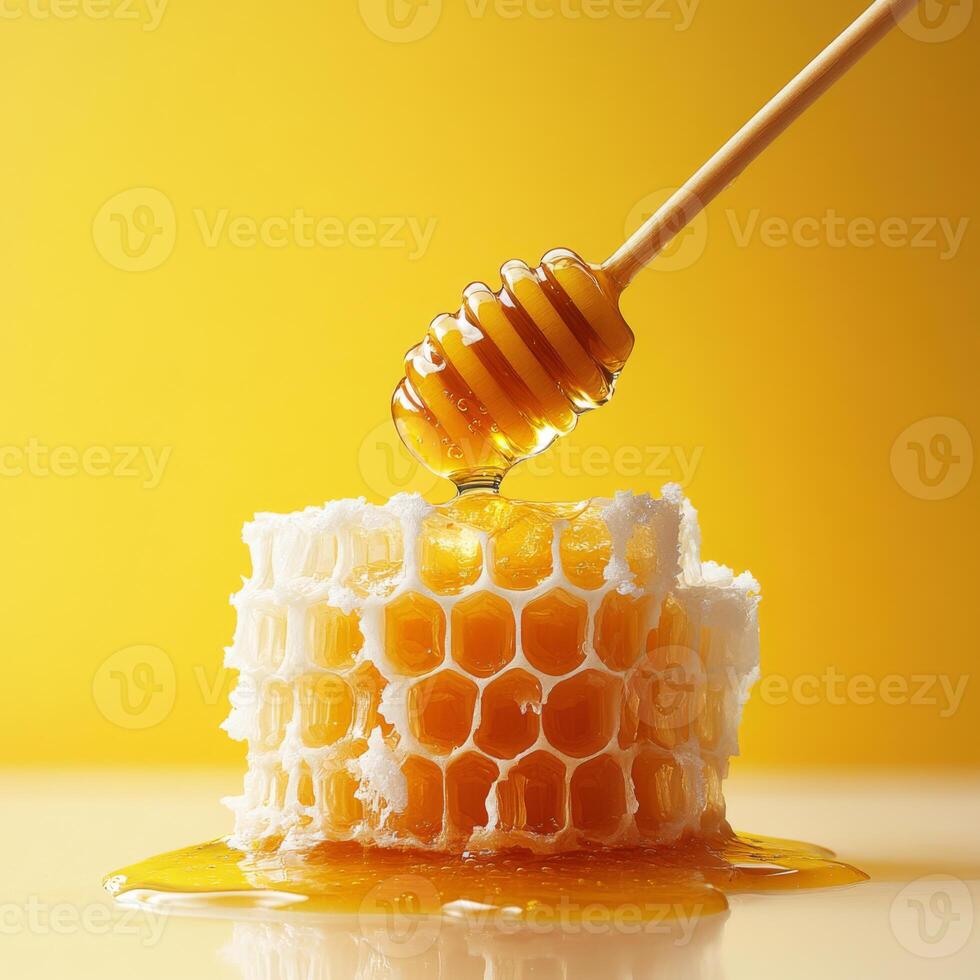 honey dipper drizzles golden honey over fresh honeycomb against vibrant yellow background, creating sweet and appetizing scene photo