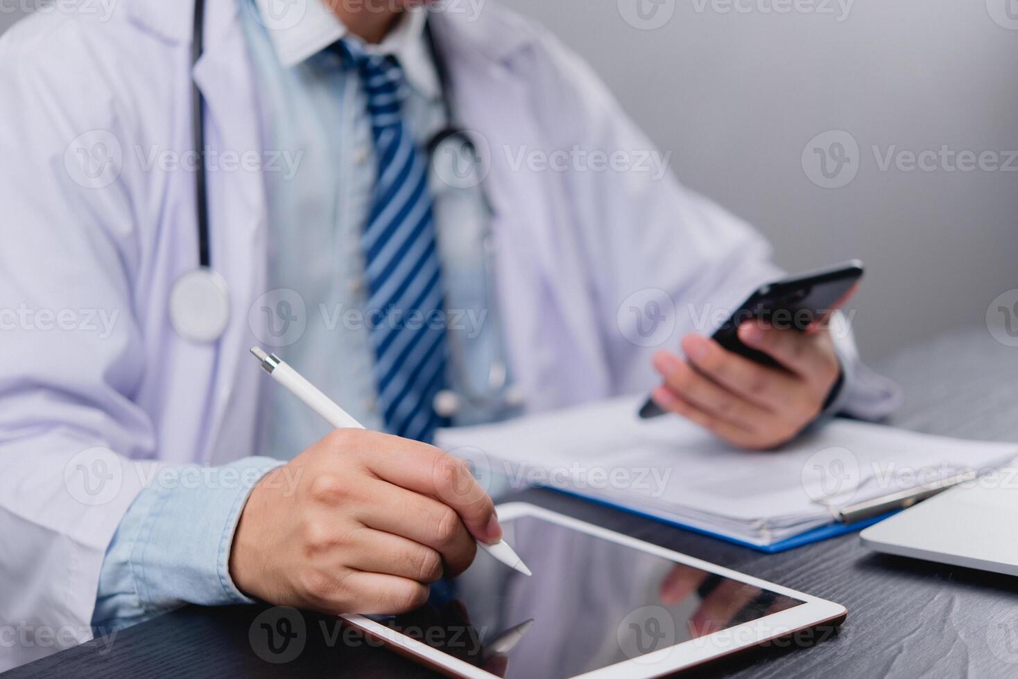 Doctor using tablet computer and pen on desk photo