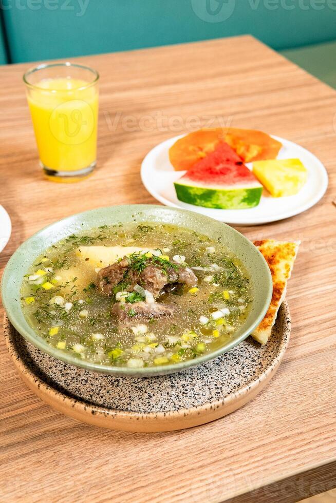 Breakfast with Eggs, Fresh Fruits, and Meat Soup photo