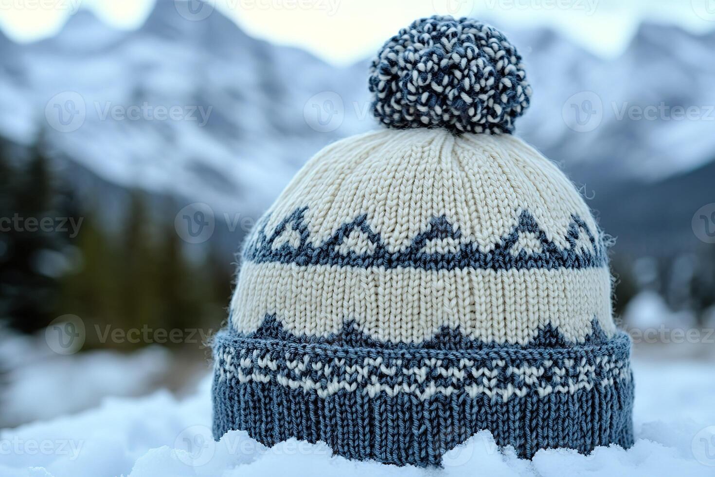 A knitted hat with a blue and white pattern sits on top of a snowy surface photo