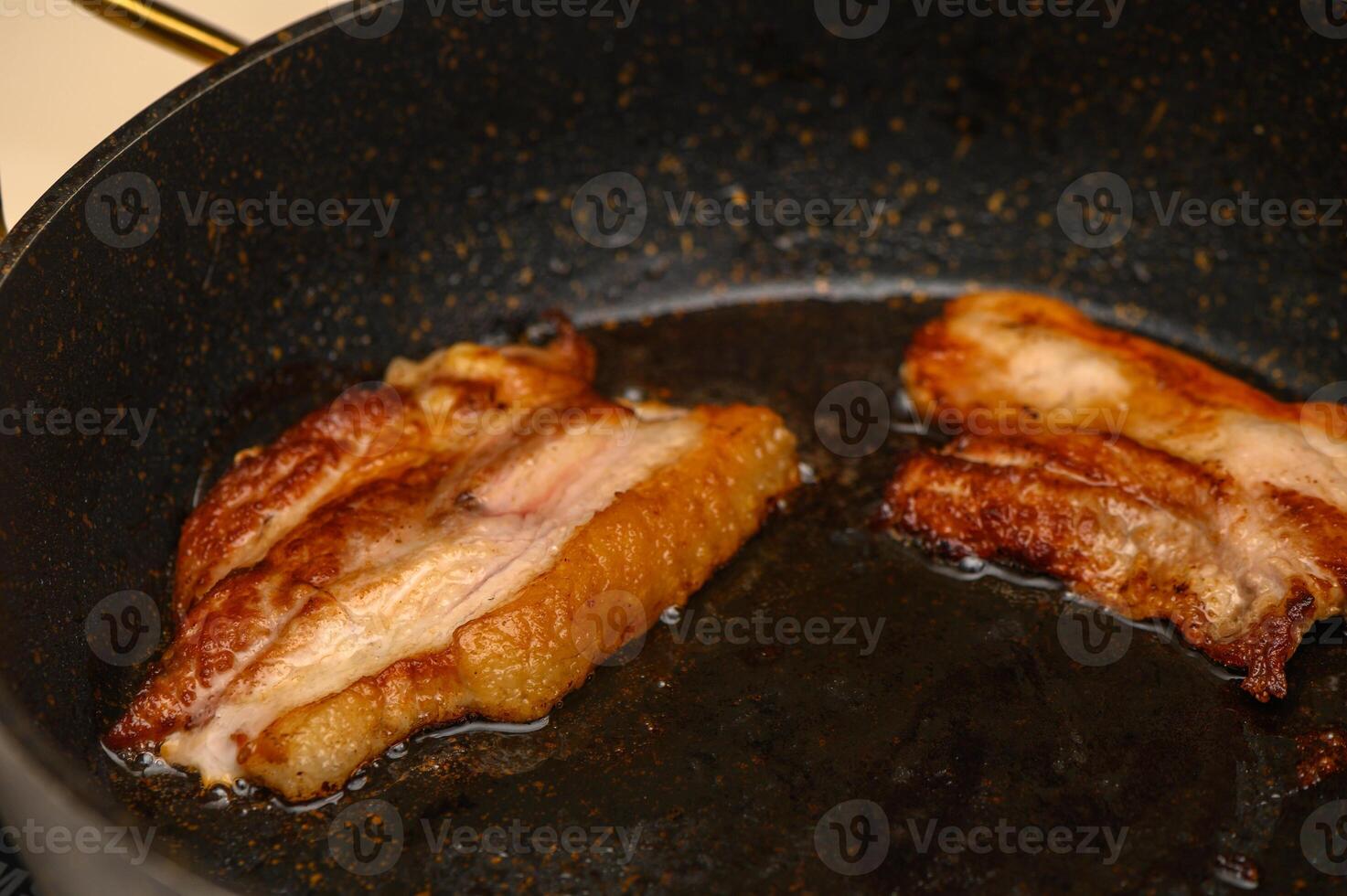Sizzling bacon strips cooking to perfection in a frying pan on a warm kitchen stovetop photo