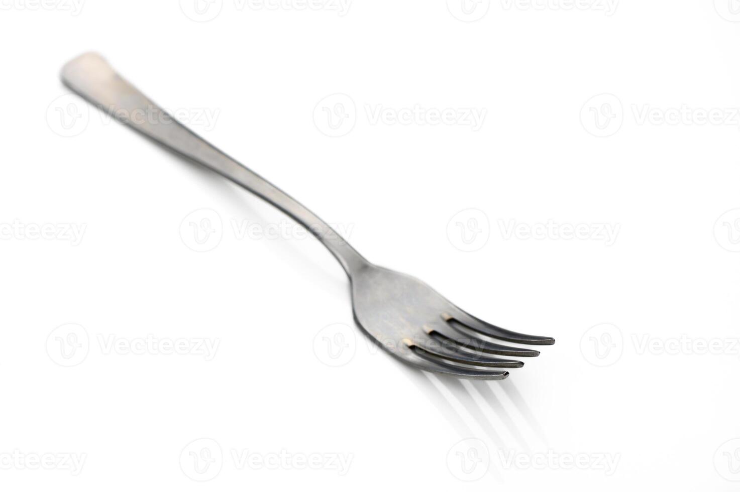 Unique fork rests on a clean white surface, highlighting its sleek design and purpose for dining photo