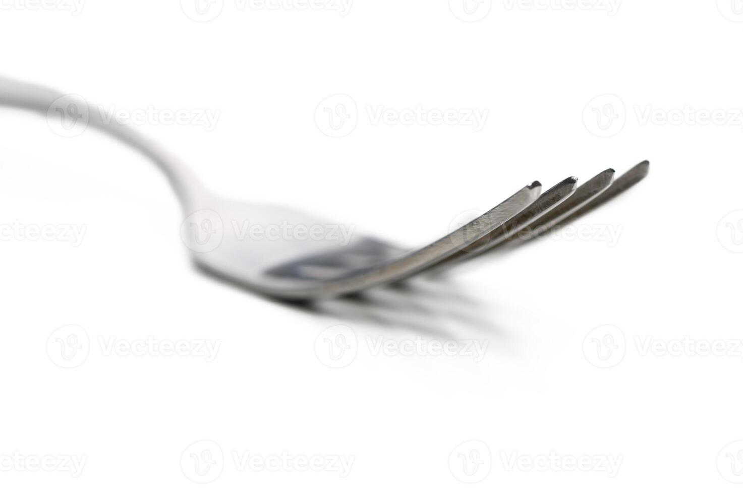 Metal fork rests on a white surface, showcasing its elegant design and fine craftsmanship in minimalistic style photo