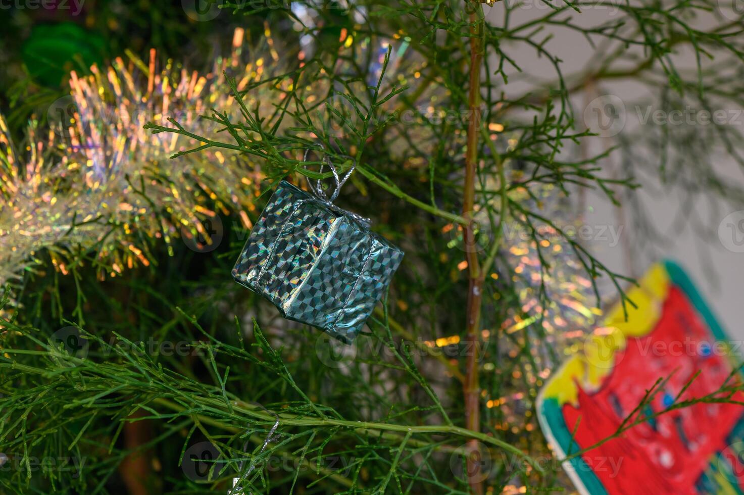 Delightful small gift ornament hanging on a festive green tree celebrating the holiday season photo