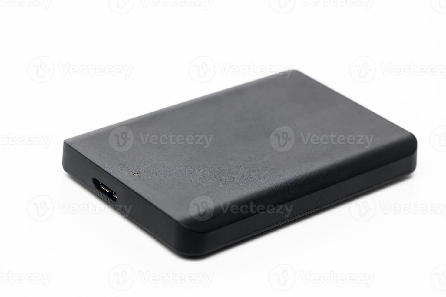 Portable external hard drive resting on a white surface, ideal for data storage and backup solutions photo