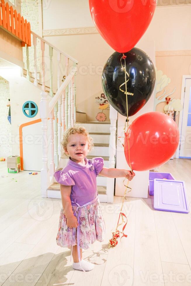 Beautiful blonde baby girl playing in kindergarten photo