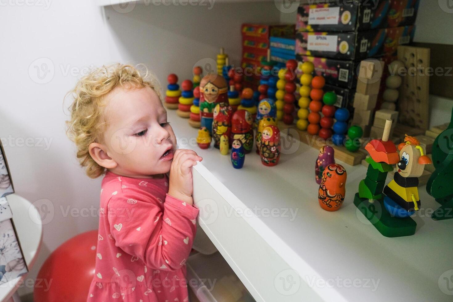 Beautiful blonde baby girl playing in kindergarten photo