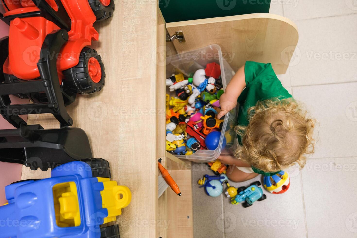 Beautiful blonde baby girl playing in kindergarten photo