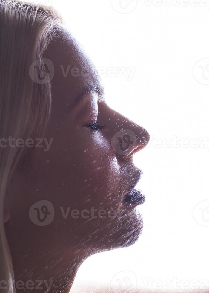 Beautiful woman applying spray water on face photo