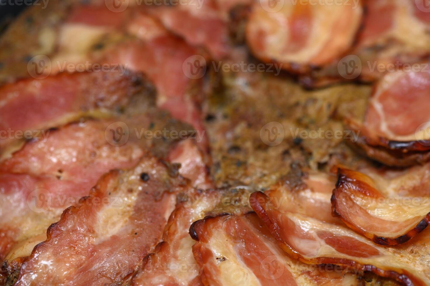 Sizzling bacon strips cooking to perfection in a cast iron skillet on a cozy kitchen stove photo
