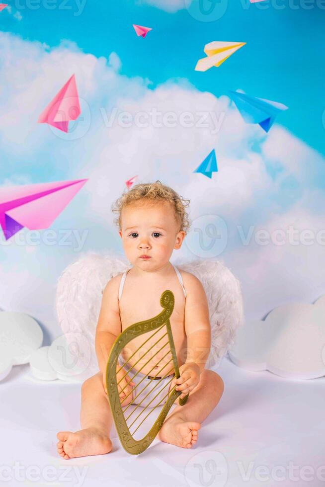 angel child is sitting the clouds looks down photo