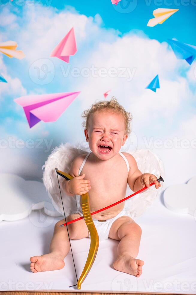 angel child is sitting the clouds looks down photo