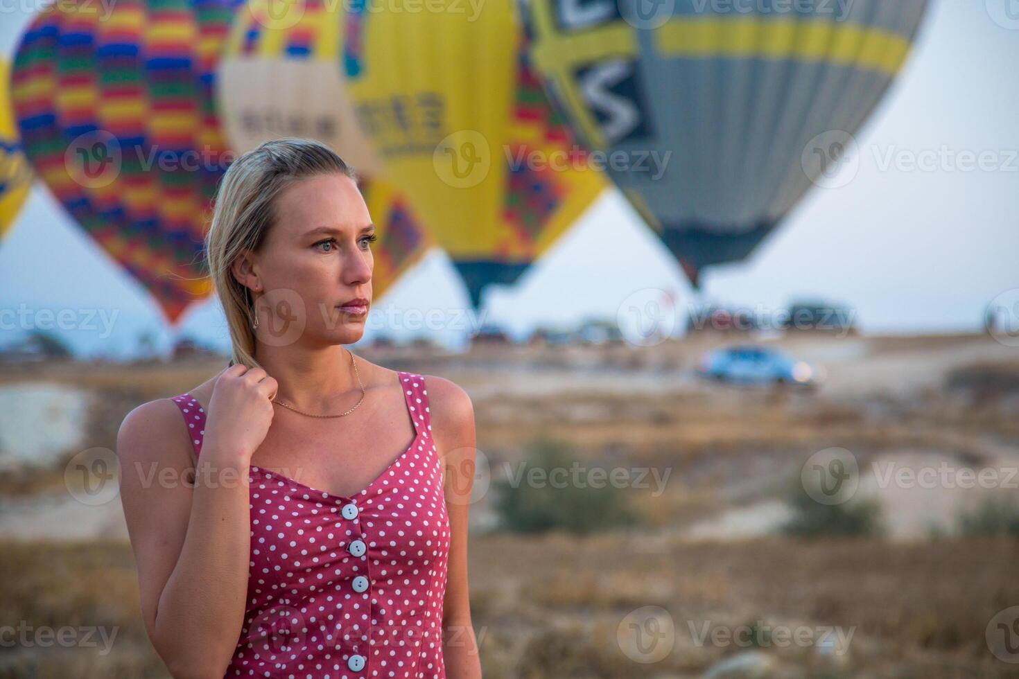 a girl is walking against the background of balloons in cappadocia photo
