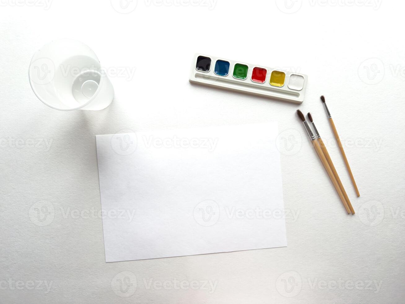 Watercolor set. Blank canvas with paints, brushes, and cup ready for artistic expression photo