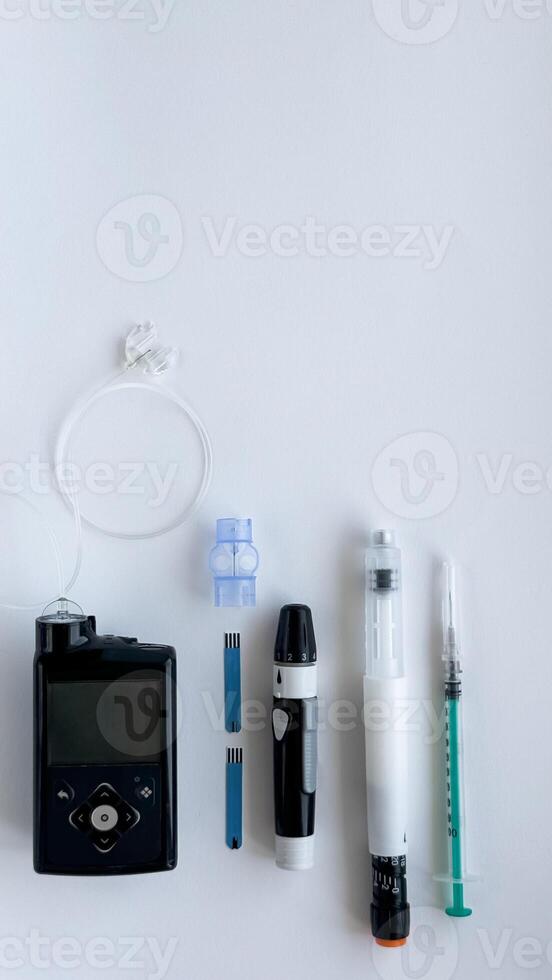 Diabetes management devices, insulin pump, glucometer, injection, and syringe on white background photo
