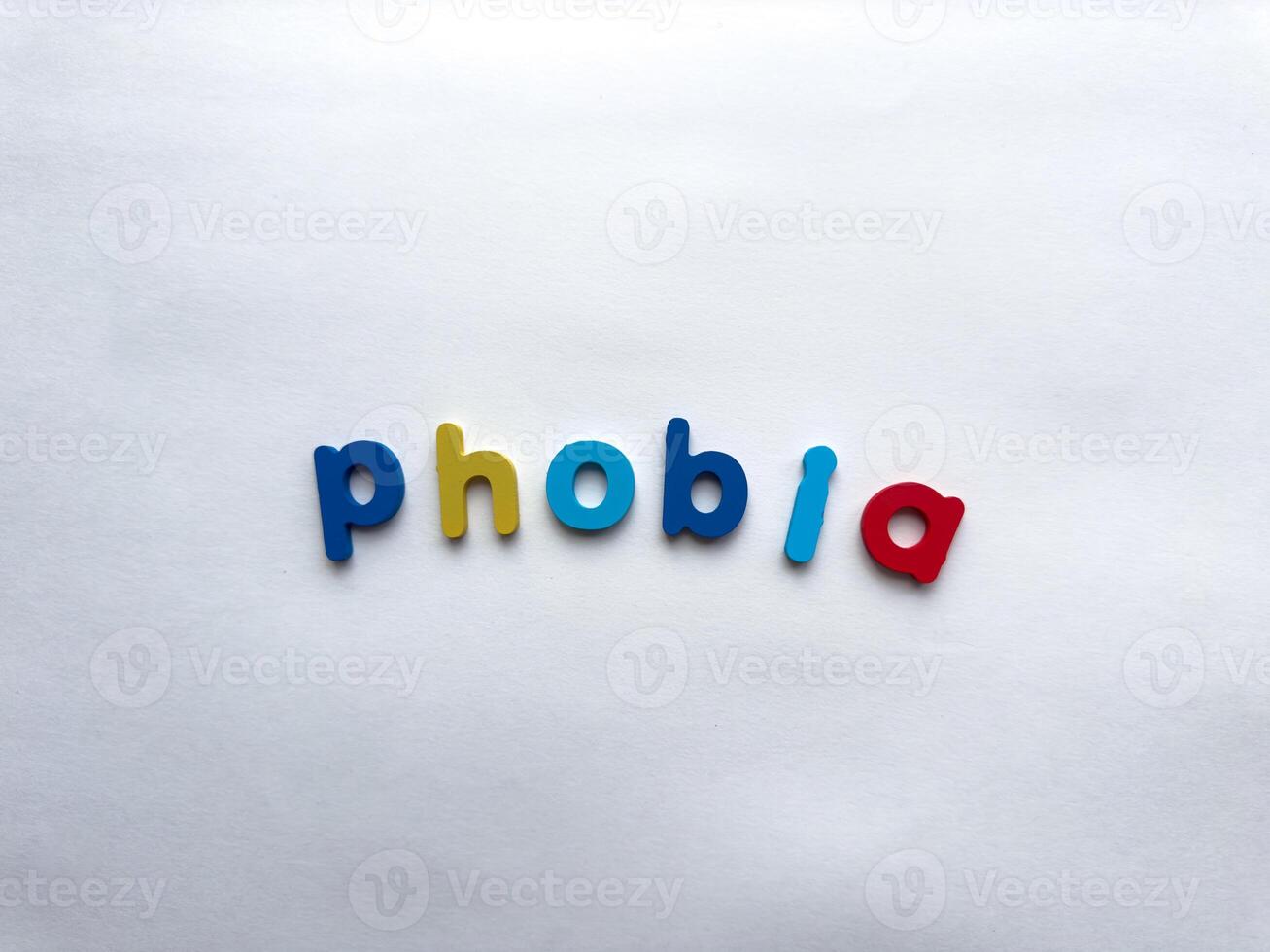 Colorful toy letters spelling phobia on white background photo