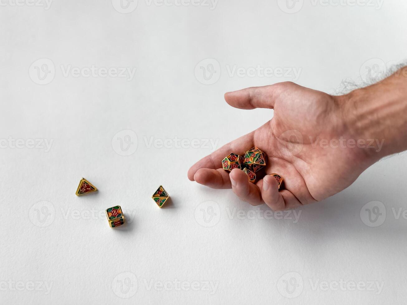 Hand holding colorful polyhedral dice on white surface for tabletop gaming photo