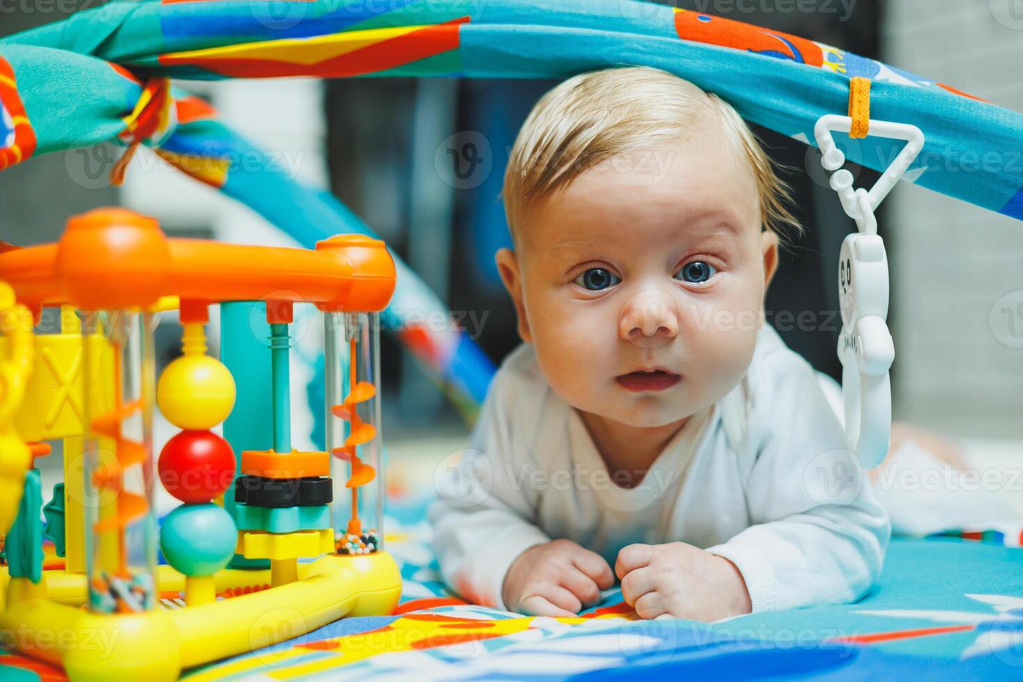 A baby plays on a developmental mat for two months. Toy rug for small children. photo